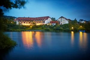 Diemelsee迪美尔西戈贝尔酒店的享有夜间河景,设有建筑