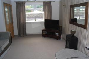 Nant-y-bwchPrincetown Cottage的客厅配有平面电视和沙发。
