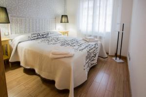 阿维拉Apartamentos Abula的卧室配有白色床和毛巾