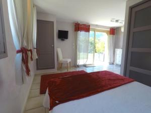 旺斯拉巴斯蒂德弗雷酒店的一间卧室配有一张床铺,床上铺有红色毯子