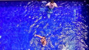 坎古Castaway Hostel的两人在蓝色的海水中游泳
