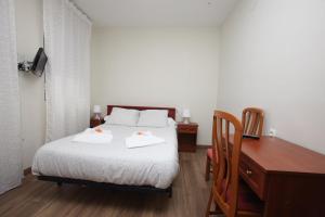 维尔根德尔卡米诺Hostal Restaurante Central的一间卧室配有一张床,上面有两条毛巾