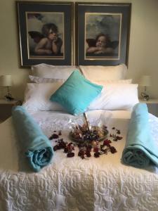 KyalamiSunninghill Sojourn的一张白色的床,上面放着一盘鲜花