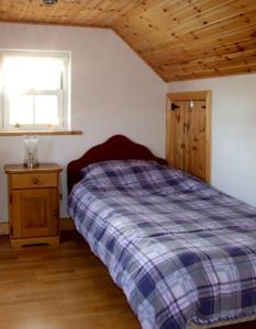 Kilkieran1 Clancy Cottages的一间卧室设有一张床和一个窗口