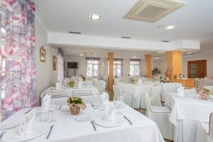 蓬特维耶斯戈维斯戈桥特雷萨酒店的宴会厅配有白色的桌子和白色的椅子