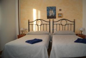 Calzadilla de los HermanillosHotel Rural Casa El Cura的客房内的两张床,上面有蓝色的毛巾