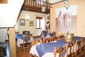 Calzadilla de los HermanillosHotel Rural Casa El Cura的用餐室配有桌椅,墙上挂有绘画作品