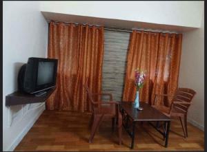 WadgaonHotel Sheetal的客厅配有电视和桌椅