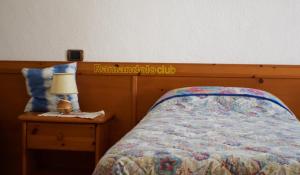 NimisCountry House Ramandolo Club的一间卧室配有一张床,床头柜上配有一盏灯