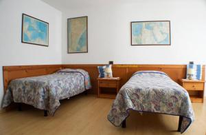 NimisCountry House Ramandolo Club的一间卧室设有两张床和两个床头柜