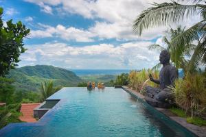 Klungkung贝拉基塔山脉度假村&Spa的水中雕像的度假村游泳池