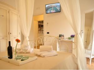 滨海波利尼亚诺Dimora Sardaro的一张带桌子、毛巾和电视的白色床