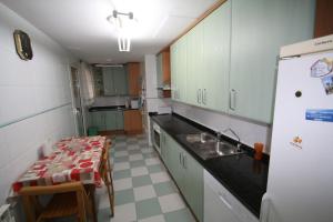 坎布里尔斯Apartamento Blau Marí的厨房配有桌子、水槽和冰箱