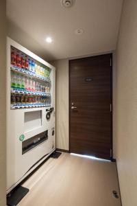 白山市全新松任终端酒店的一间设有门和饮料冰箱的房间