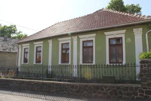 TállyaHomoky Pincészet és Vendégház的一座带围栏的绿色白色小房子