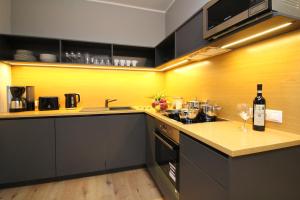 塔林老城套房塔林城市公寓式酒店的厨房配有黑色橱柜和黄色的墙壁