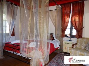 切佩洛沃Hotel Kamares的一间卧室配有带窗帘的床和椅子