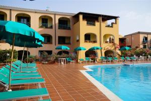 卡拉·利贝罗托Nicolaus Club Torre Moresca的游泳池旁的酒店拥有椅子和遮阳伞