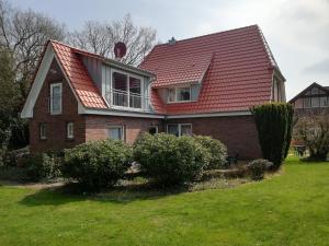 巴德茨维什安Pension-Marion的一座有红色屋顶和灌木的房子