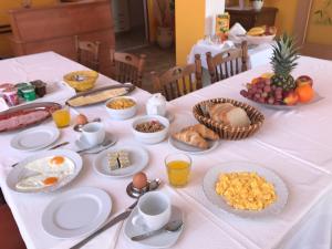 拉布Guest House Sandra的一张桌子,上面有早餐食品,放在白色的桌布上