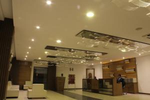 艾哈迈达巴德白金酒店的一个人站在一个有灯光的天花板的大堂