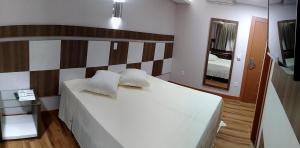 托莱多Hotel Maestro Villa Do Lago Toledo的卧室配有一张带镜子的白色大床