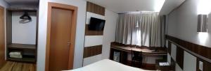 托莱多Hotel Maestro Villa Do Lago Toledo的一间卧室配有一张床和一台电视。
