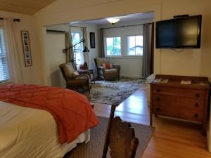 Willow CreekChina Creek Cottages的一间卧室配有一张床和一台平面电视
