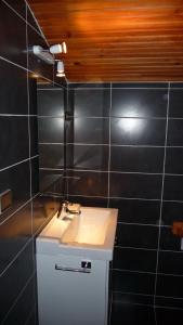 图卢兹Chez Babeth的浴室设有白色水槽和黑色瓷砖