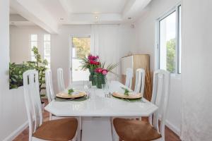 丰沙尔Susy’s Garden的白色的用餐室配有白色的桌椅