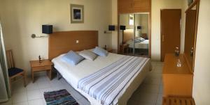 阿尔沃尔Apartamento T1 Quinta Nova - Alvor的一间卧室配有一张大床和镜子