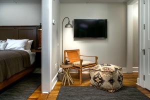 Saint PaulWestern Front Hotel的一间卧室配有一张床、一把椅子和电视。