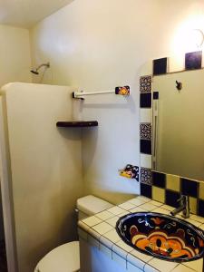 埃斯孔迪多港Cielito Lindo Suites的一间带卫生间和水槽的小浴室