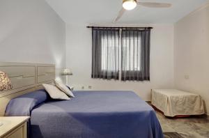 拉海瑞德拉Marina Playa的一间卧室设有蓝色的床和窗户。