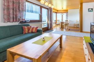 艾琴堡Haus Margit的客厅配有绿色沙发和木桌