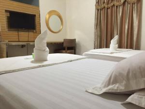 SolanoMeaco Hotel - Solano的一间卧室配有两张带白色床单和镜子的床