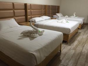 SolanoMeaco Hotel - Solano的一间设有三张床的房间,上面有天鹅
