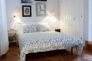 马德里Elegante piso junto al Museo del Prado的一间卧室配有一张带白色床罩的床