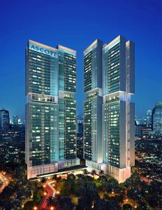 雅加达Ascott Sudirman Jakarta的一群摩天大楼在城市的夜晚