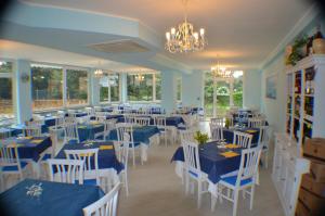 毕博纳的码头绿色天堂酒店的用餐室配有蓝色桌子和白色椅子