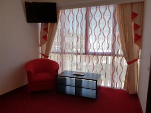 MotruPensiunea Ghiocela的一间设有红色椅子、桌子和窗户的房间