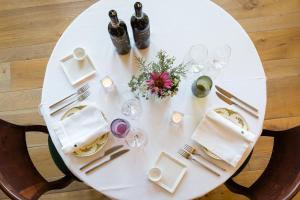 加维Locanda La Raia的一张带葡萄酒瓶和玻璃杯的白色桌子
