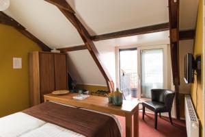 Birdaard伊特博萨斯餐厅酒店的一间卧室配有一张床、一张书桌和一个窗户。