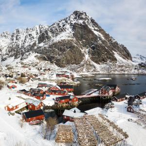 奥镇Å Rorbuer - by Classic Norway Hotels的被雪覆盖的村庄,背景是山