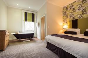 伯恩茅斯格林别墅酒店的酒店客房配有一张床和浴缸。