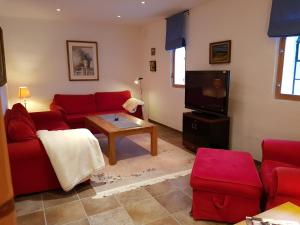 英斯约琳达格尔达公寓酒店的客厅配有红色沙发和电视