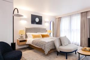 伦敦罗克韦尔东塔桥公寓式酒店的一间卧室配有一张床、一把椅子和一张沙发