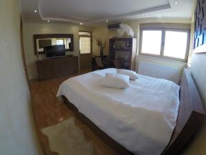 康斯坦察Casa Edwin的卧室配有白色的床和电视。