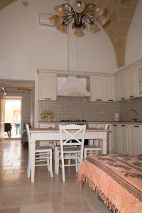 GiulianoCasa Jacqueline al borgo的厨房配有白色橱柜和桌椅
