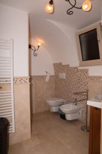 GiulianoCasa Jacqueline al borgo的一间带卫生间和水槽的浴室以及一台电视。